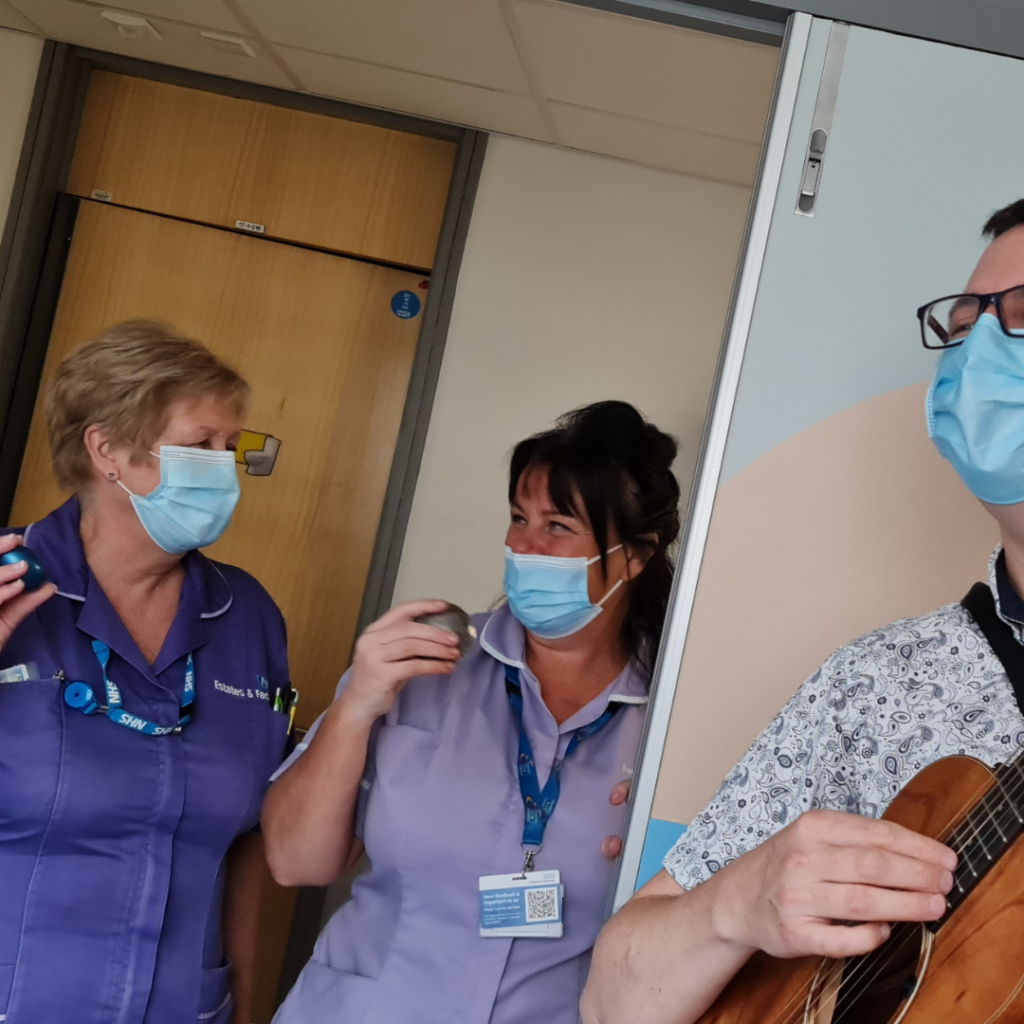 Two healthcare professionals playing music with Nick
