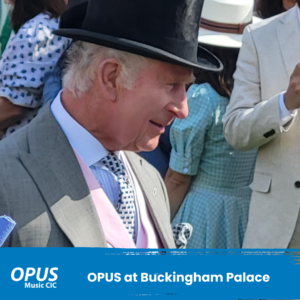 OPUS at Buckingham Palace with a picture of King Charles